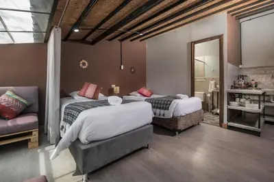 a bedroom with two beds and a couch and a mirror at Casa Cavassa Centro Histórico Cusco in Cusco