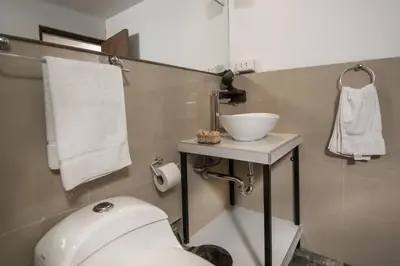 a bathroom with a white toilet and a sink at Casa Cavassa Centro Histórico Cusco in Cusco