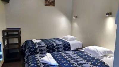 two beds in a room with blue and white sheets at Casa Grande Colonial Palace in Cusco