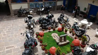a group of motorcycles parked in a courtyard with plants at Casa Grande Colonial Palace in Cusco