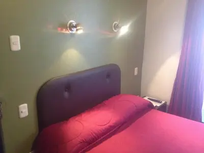 a bedroom with a bed with a red bedspread at Casa Grande Colonial Palace in Cusco