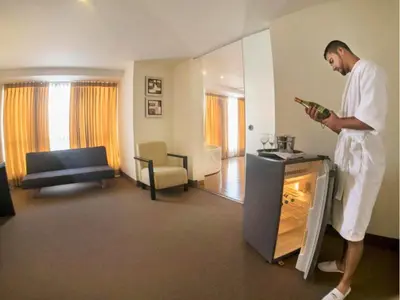 a man standing in a living room playing a video game at Allpa Hotel & Suites in Lima