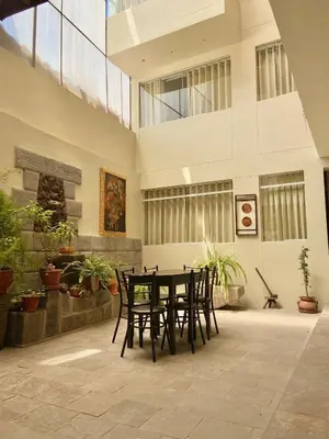 a table and chairs in a room with plants at Hostal Casona Arrambide in Cusco