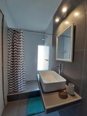a bathroom with a sink and a shower at El Huerto Hostel in Ica