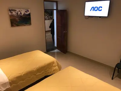 a room with a bed and a tv on the wall at Edmoli Casa Hospedaje in Cusco
