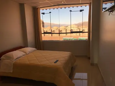 a bedroom with a bed and a large window at Edmoli Casa Hospedaje in Cusco