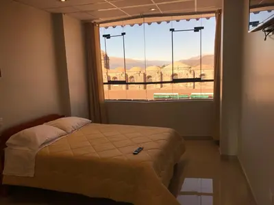 a bedroom with a bed and a large window at Edmoli Casa Hospedaje in Cusco