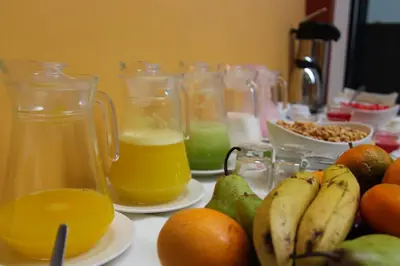 a table topped with jars of orange juice and fruit at Hotel Limacpampa in Cusco