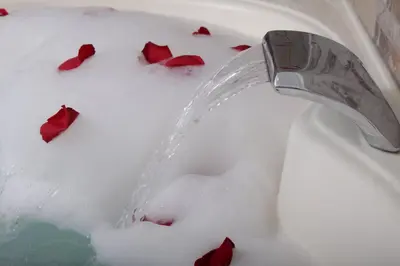a water faucet in a sink with red roses at Montreal Magdalena Del Mar Hotel in Lima