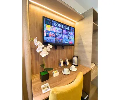 a room with a table with a television on a wall at Montreal Magdalena Del Mar Hotel in Lima
