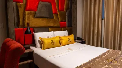 a bedroom with a bed with yellow and red pillows at Montreal Magdalena Del Mar Hotel in Lima