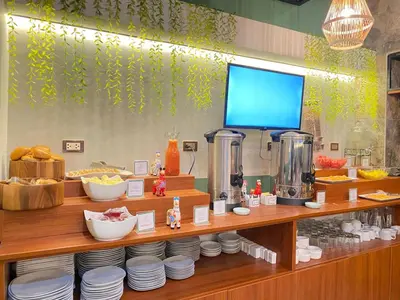 a counter with plates and other food items on it at Montreal Magdalena Del Mar Hotel in Lima