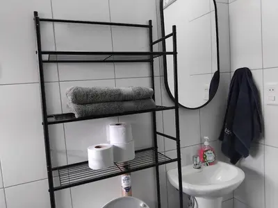 a bathroom with a shelf with towels and a sink at Studio in historic center Cusco in Cusco