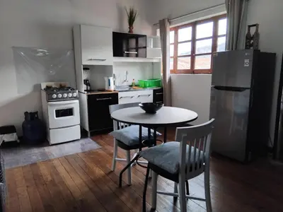 a kitchen with a table and chairs and a refrigerator at Studio in historic center Cusco in Cusco