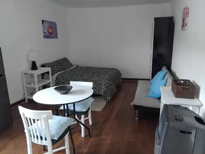 a small living room with a table and a bed at Studio in historic center Cusco in Cusco