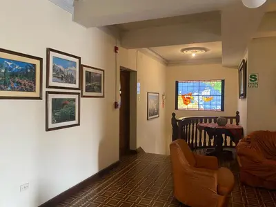a hallway with a living room with a table and chairs at Hotel San Isidro Inn in Lima
