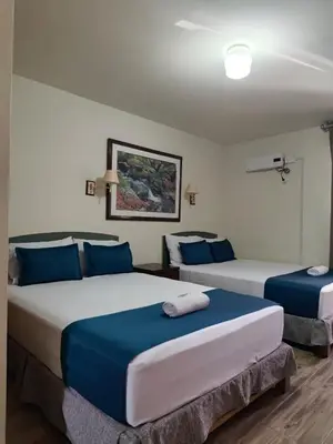 two beds in a room with blue and white at Hotel San Isidro Inn in Lima