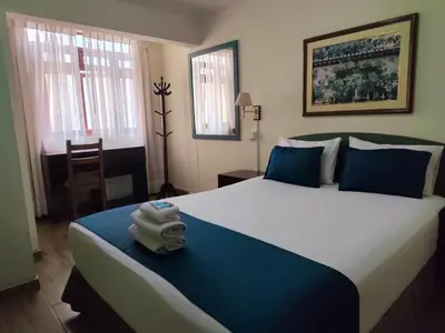 a bedroom with a large bed with a towel on it at Hotel San Isidro Inn in Lima