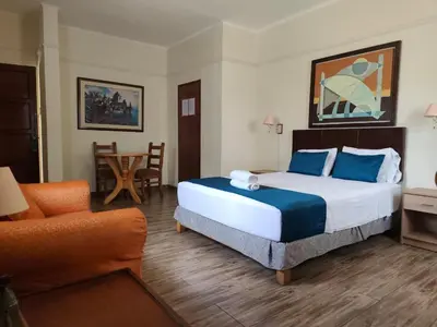 a bedroom with a large bed with blue pillows at Hotel San Isidro Inn in Lima