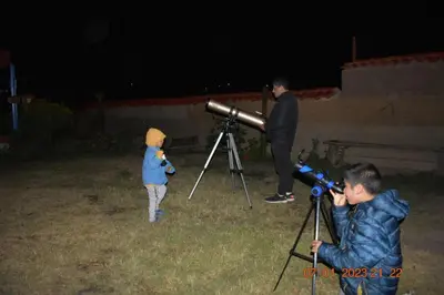 a man taking a picture of a child with a telescope at La Finca Tarma in Tarma