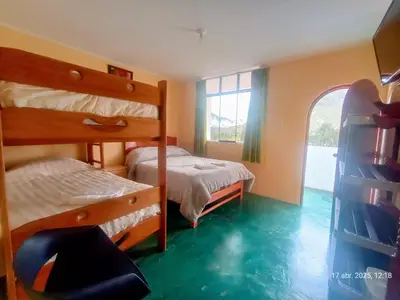 a bedroom with two bunk beds and a window at La Finca Tarma in Tarma