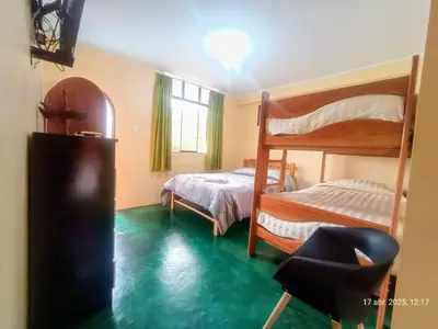 a bedroom with two bunk beds and a green floor at La Finca Tarma in Tarma