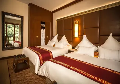a hotel room with two beds and a mirror at Sumaq Machu Picchu Hotel in Machu Picchu