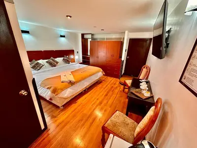 a hotel room with a bed and a table and chairs at Mama's House in Cusco