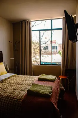 a bedroom with a bed and a large window at Del Valle House in Ica