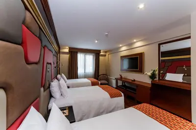 a hotel room with two beds and a television at Yawar Inka Hotel in Cusco