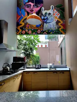 a kitchen with a sink and a painting on the wall at 3B Barranco by Katari Hoteles in Lima