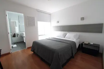 a bedroom with a large bed and a bathroom at 3B Barranco by Katari Hoteles in Lima