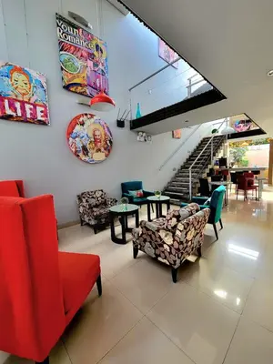 a living room with chairs and tables and a staircase at 3B Barranco by Katari Hoteles in Lima