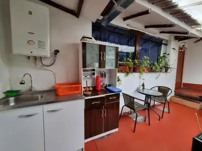 a kitchen with white cabinets and a table with chairs at La Casa de Laura - Plaza in Cusco