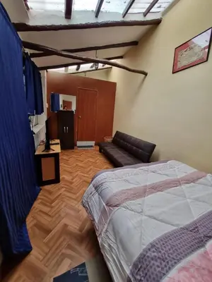 a bedroom with a bed and a couch in a room at La Casa de Laura - Plaza in Cusco