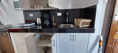 a small kitchen with a sink and white cabinets at La Casa de Laura - Plaza in Cusco