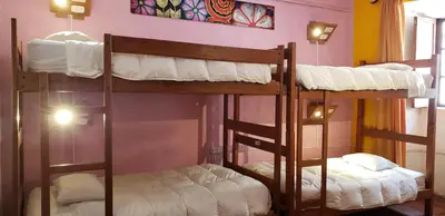 two bunk beds in a room with a wall at Pirwa Backpackers Colonial in Cusco