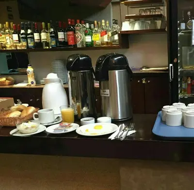 a kitchen counter with plates of food and a coffee maker at Kamana Hotel in Lima
