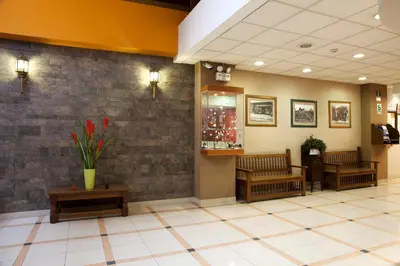 a waiting room with benches and a stone wall at Kamana Hotel in Lima