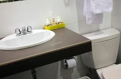 a bathroom with a sink and a toilet at Kamana Hotel in Lima