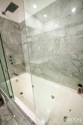 a shower with a glass door in a bathroom at Moon Luxury Apartments in Lima
