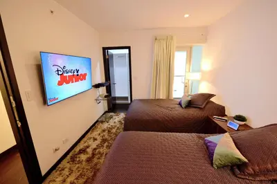 a hotel room with two beds and a television at Moon Luxury Apartments in Lima