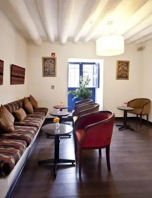 a living room with a couch and chairs and tables at Tierra Viva Cusco Saphi Hotel in Cusco