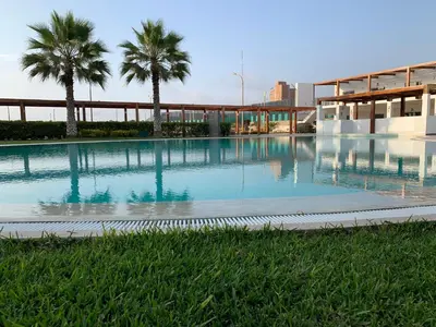 a large swimming pool with palm trees in front of a building at La Casa del Jota in Asia