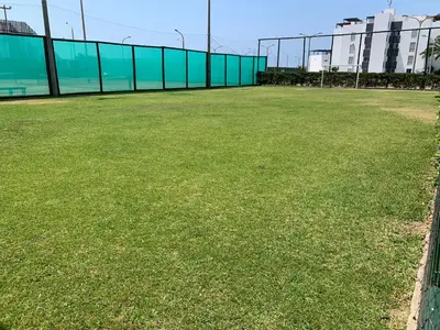 a large grass field with a fence and buildings at La Casa del Jota in Asia