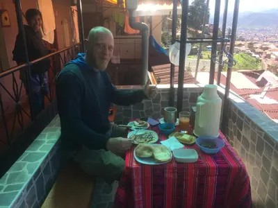 a man sitting at a table with a plate of food at Wichana Wasi in Cusco