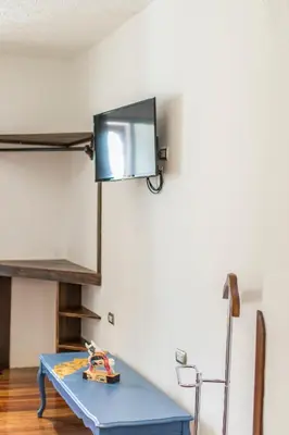 a room with a blue table and a tv on the wall at X.O Art House in Cusco