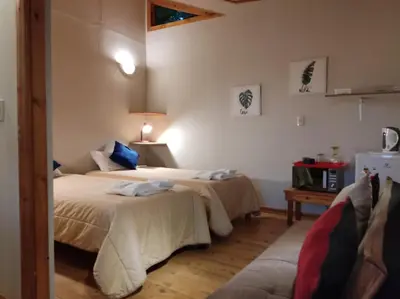a bedroom with two beds and a couch at San Alberto Ecolodge in Oxapampa
