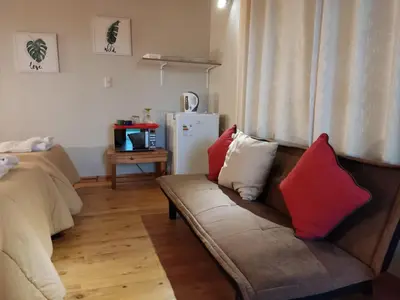 a living room with a couch with red and white pillows at San Alberto Ecolodge in Oxapampa