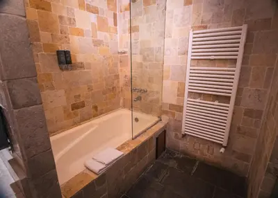 a bathroom with a tub and a glass shower at Tambo del Arriero Hotel Boutique in Cusco